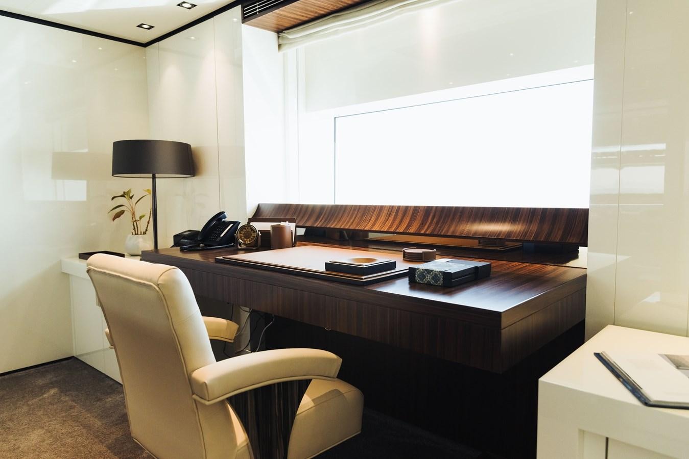 a desk with a chair and a computer on it aboard LUCKY ME Yacht for Sale