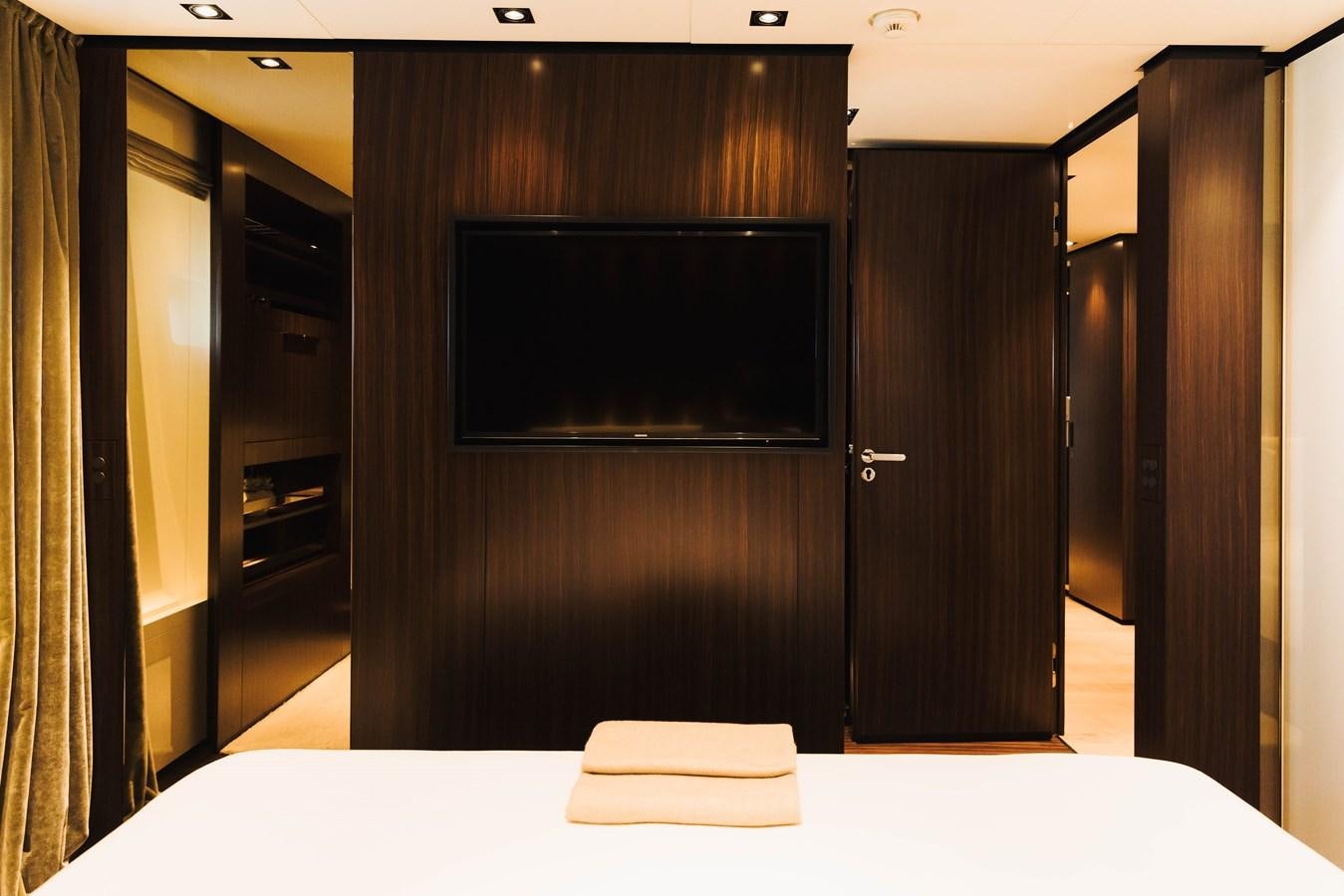 a room with a tv and a bed aboard LUCKY ME Yacht for Sale