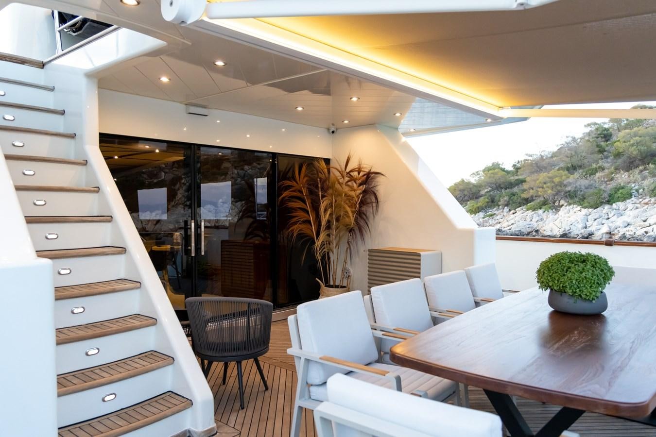 a room with a table chairs and plants aboard AQUILLA Yacht for Sale