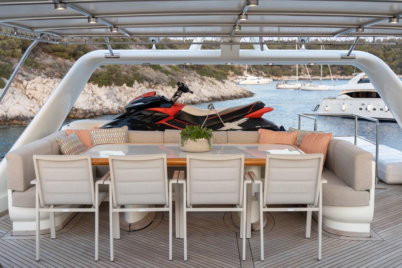 a table and chairs on a deck aboard AQUILLA Yacht for Sale