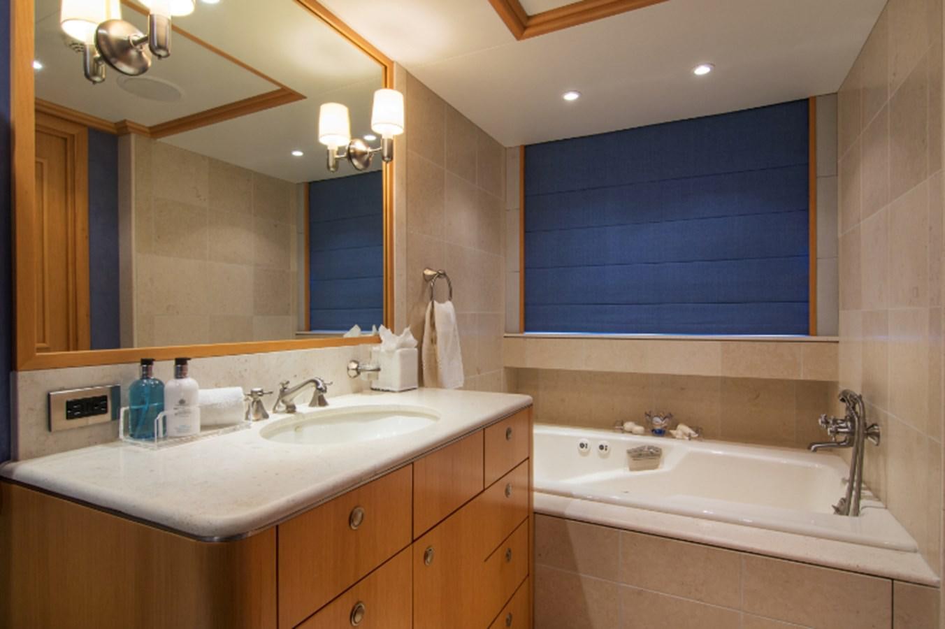 a bathroom with a tub sink and a mirror aboard 4*PUPPIES Yacht for Sale