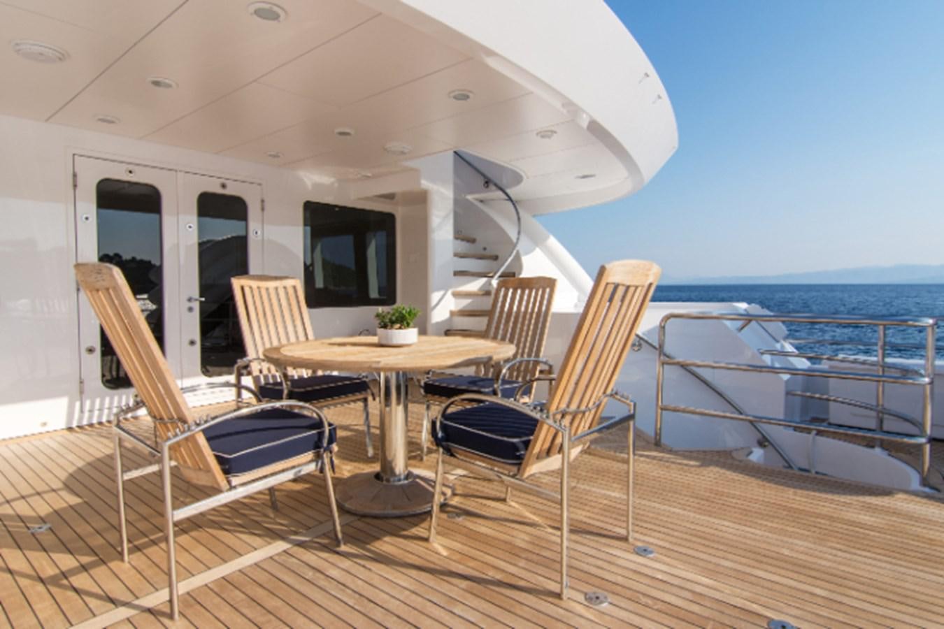 a deck with chairs and tables on it aboard 4*PUPPIES Yacht for Sale