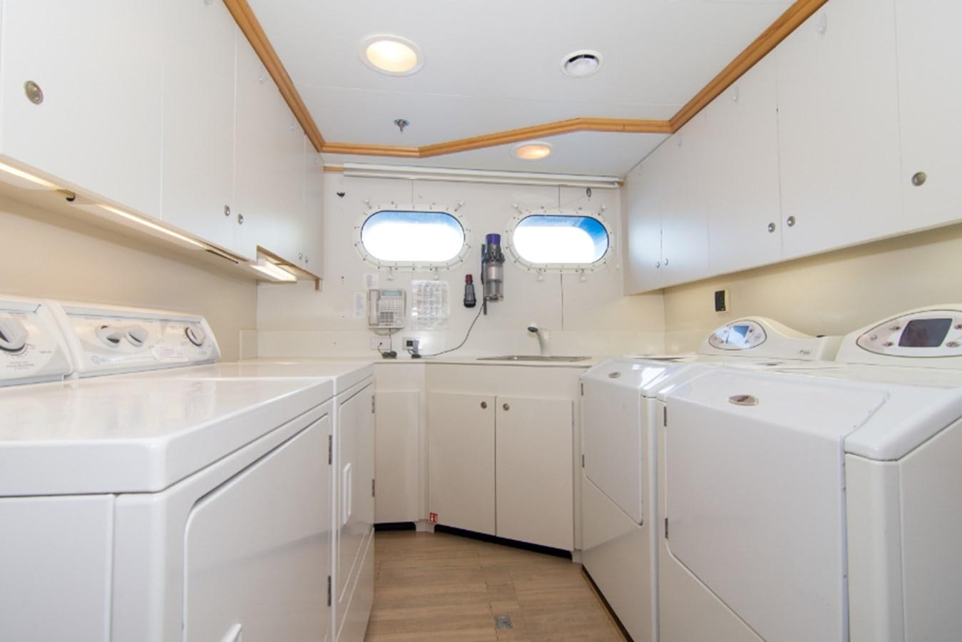 a kitchen with white cabinets aboard 4*PUPPIES Yacht for Sale