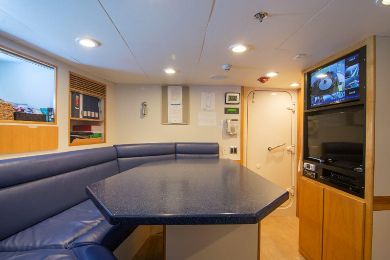 a living room with a table and tv aboard 4*PUPPIES Yacht for Sale