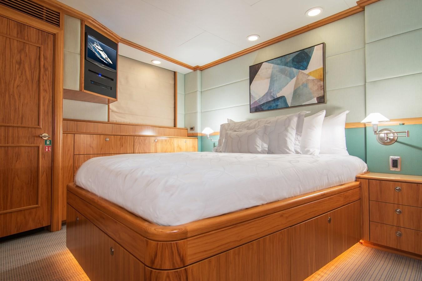 a bed with a television on the wall aboard 4*PUPPIES Yacht for Sale
