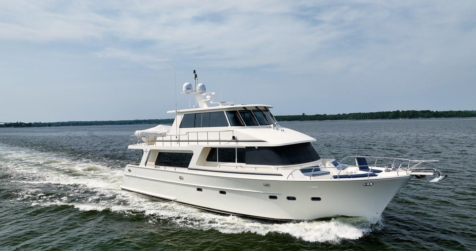 a white boat on the water aboard THREE OF A KIND Yacht for Sale