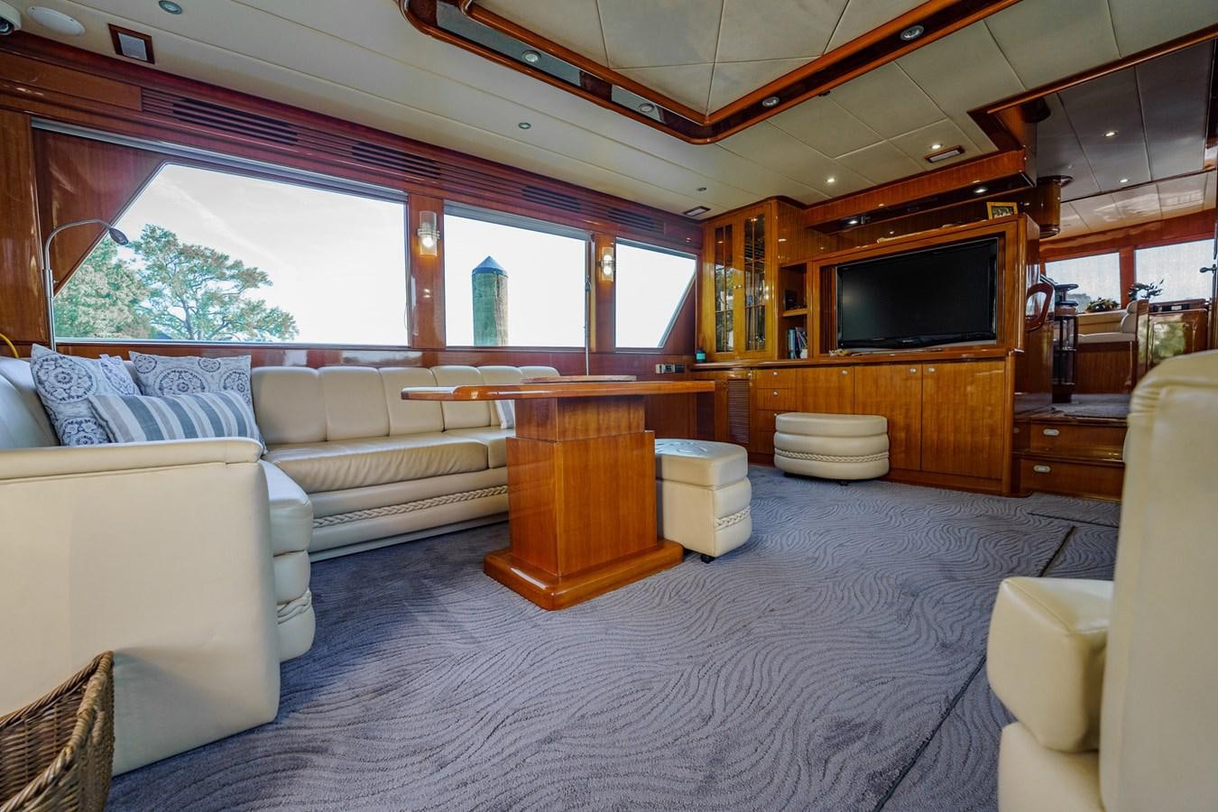 a living room with a couch and a television aboard THREE OF A KIND Yacht for Sale