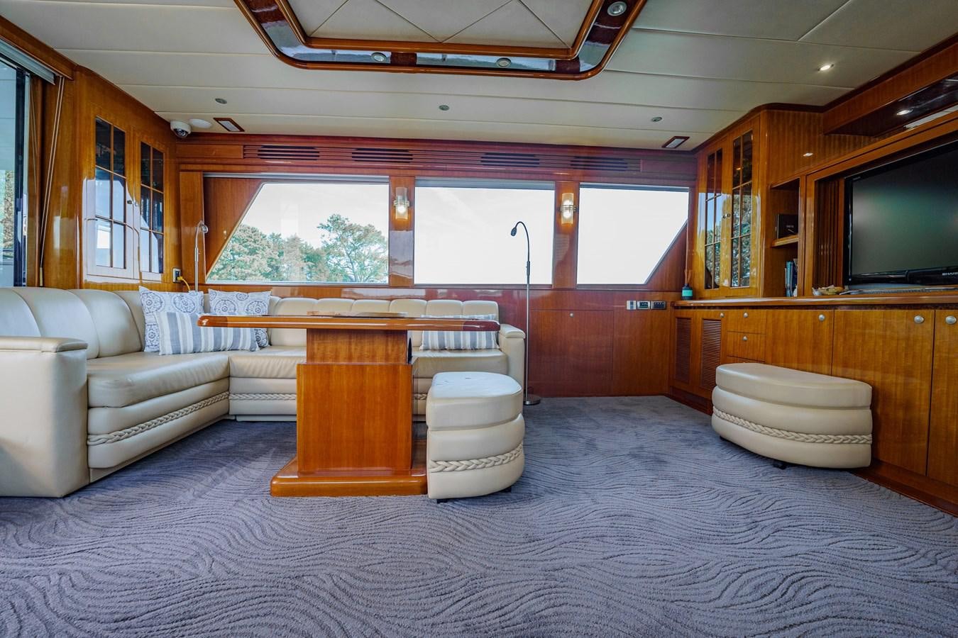 a large living room with a couch and a table aboard THREE OF A KIND Yacht for Sale
