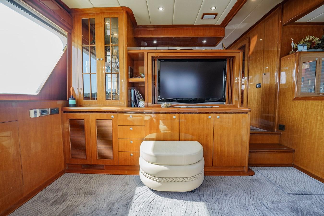 a bathroom with a tv and cabinets aboard THREE OF A KIND Yacht for Sale