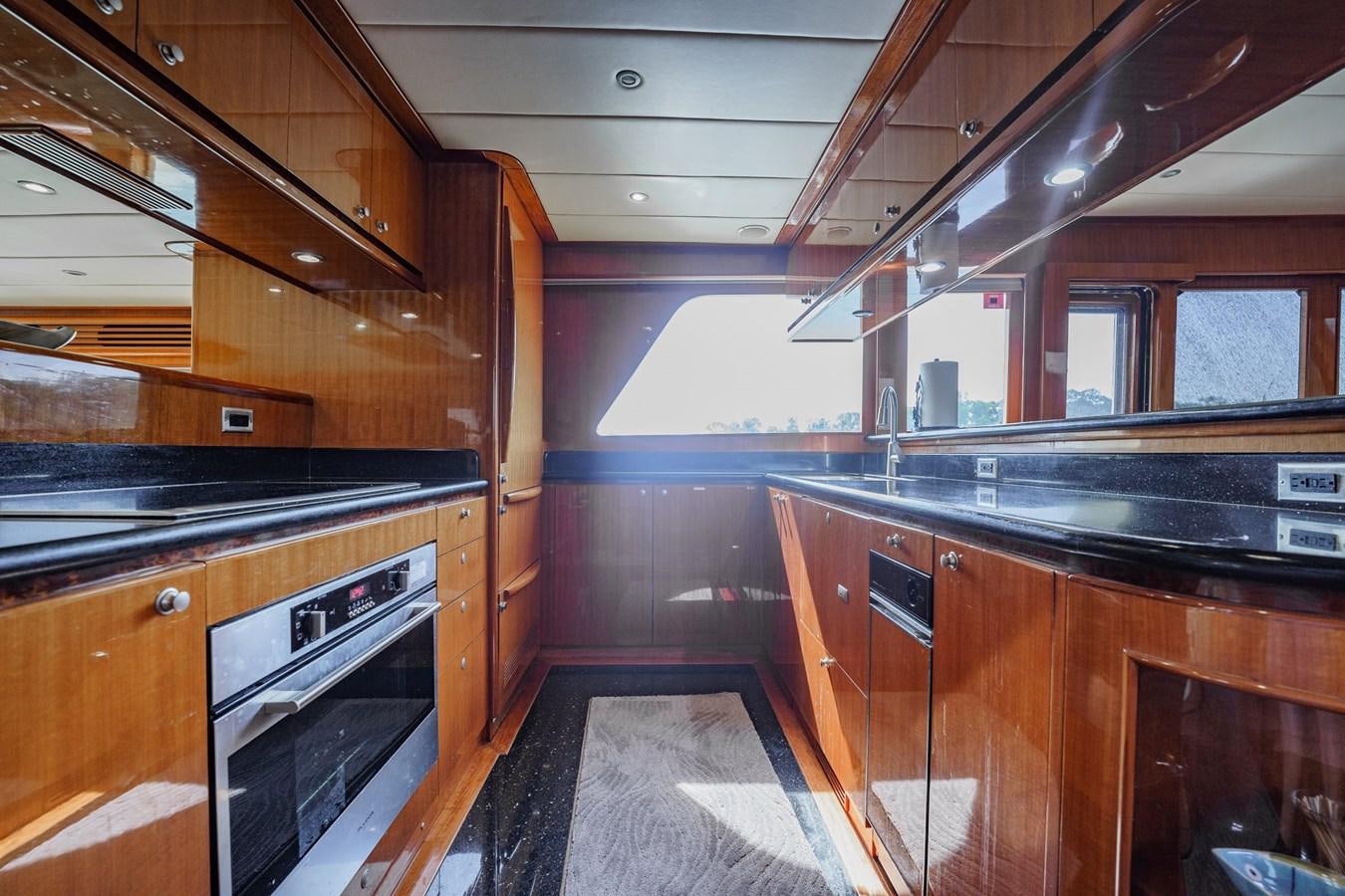 a kitchen with wooden cabinets aboard THREE OF A KIND Yacht for Sale