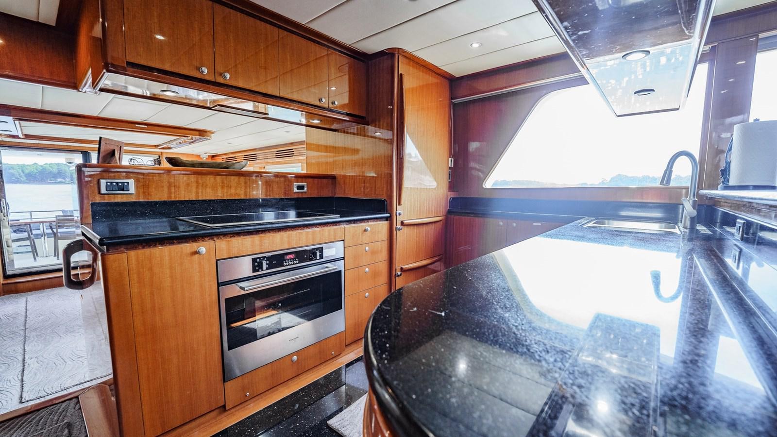 a kitchen with wooden cabinets aboard THREE OF A KIND Yacht for Sale