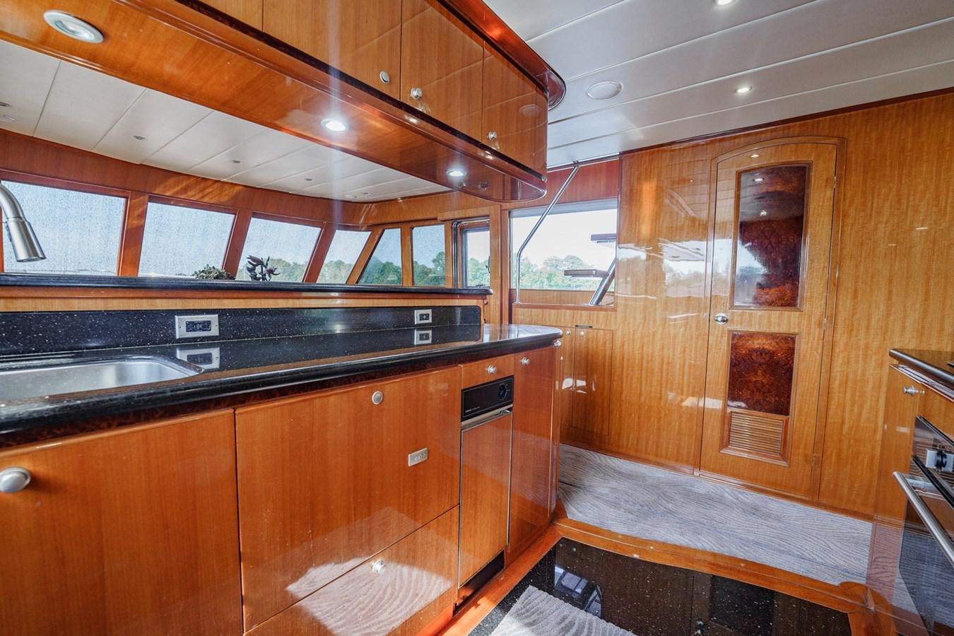 a kitchen with wooden cabinets aboard THREE OF A KIND Yacht for Sale