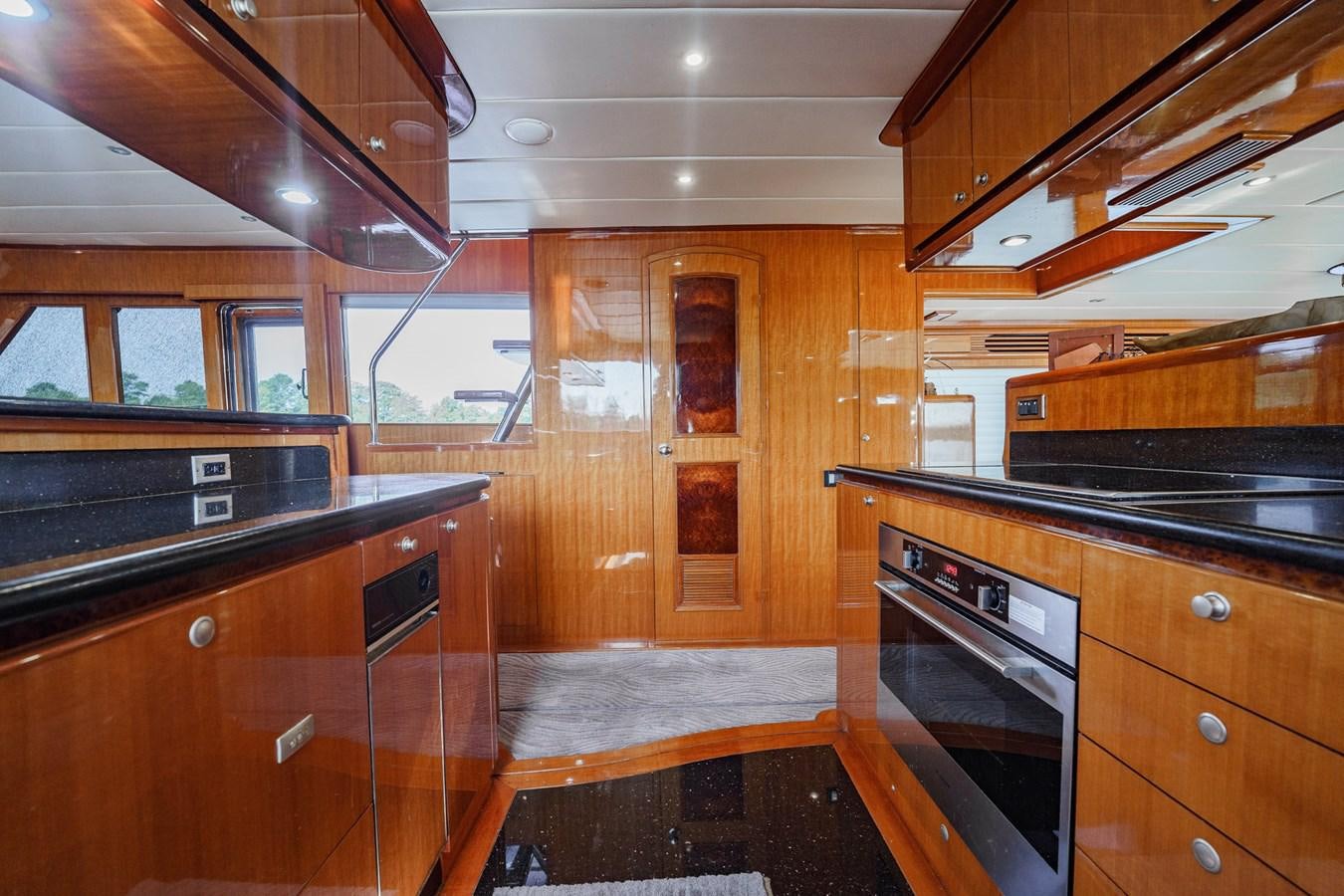 a kitchen with wooden cabinets aboard THREE OF A KIND Yacht for Sale