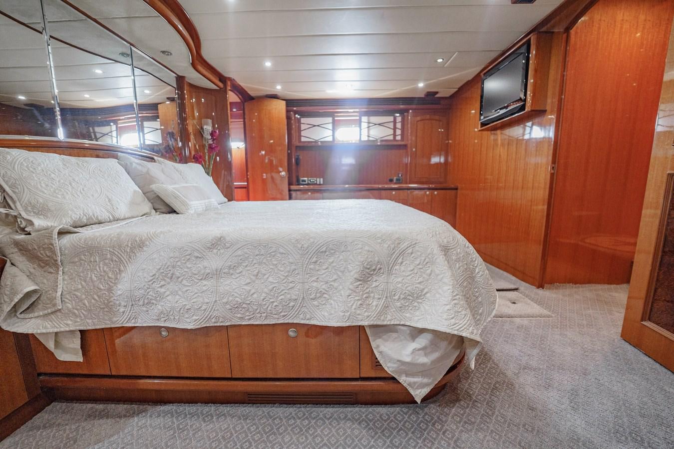 a room with a bed and a television aboard THREE OF A KIND Yacht for Sale