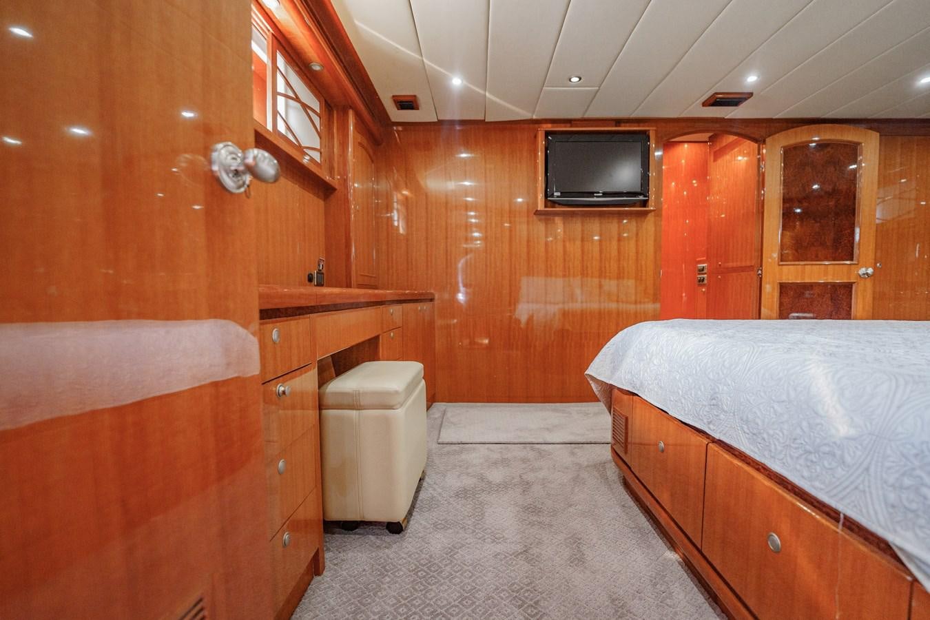 a bedroom with a bed and a tv aboard THREE OF A KIND Yacht for Sale