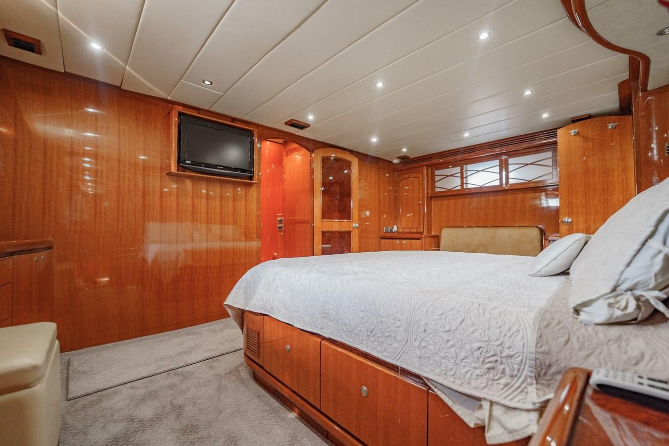 a bedroom with a bed and a television aboard THREE OF A KIND Yacht for Sale