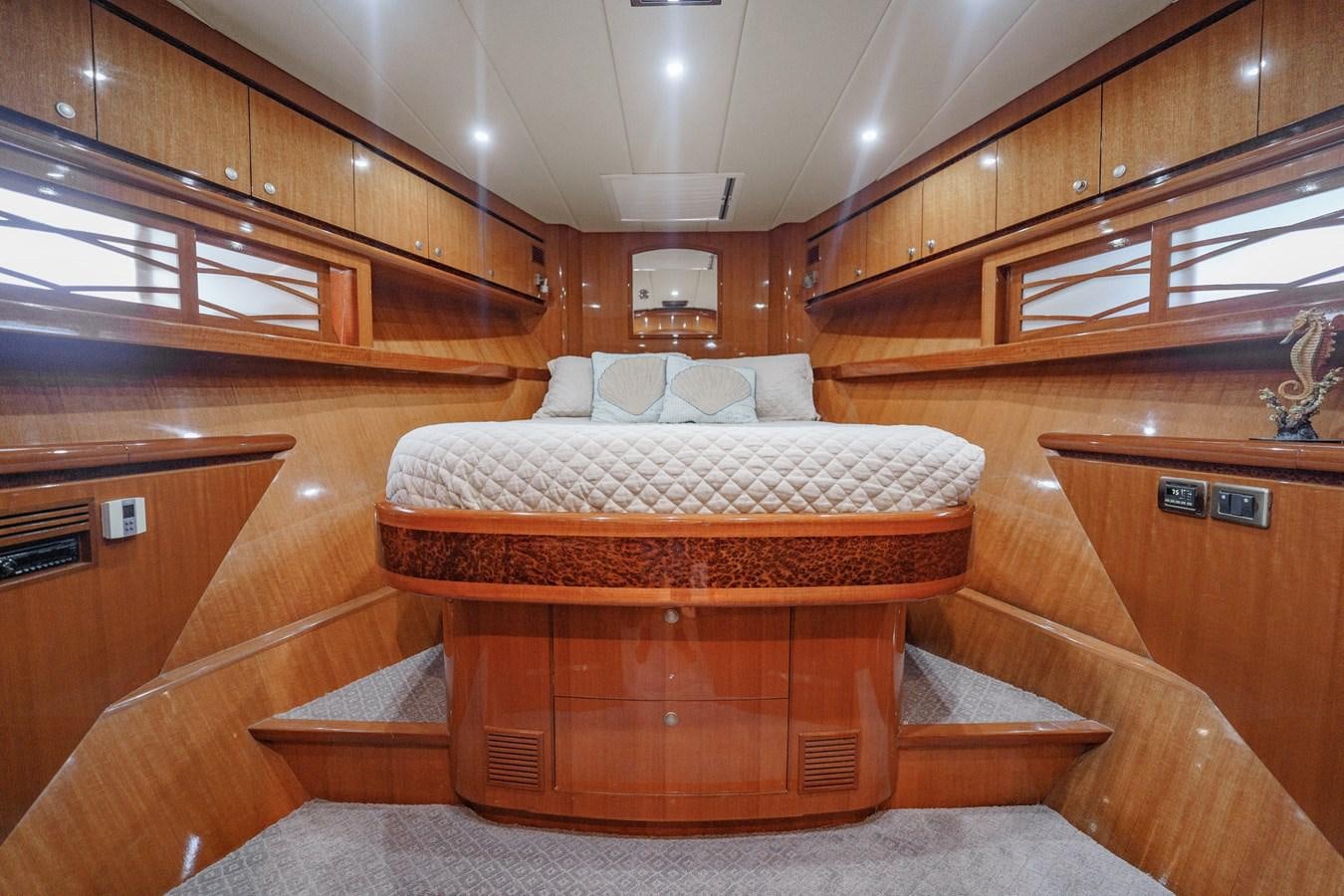 a bedroom with a bed and cabinets aboard THREE OF A KIND Yacht for Sale