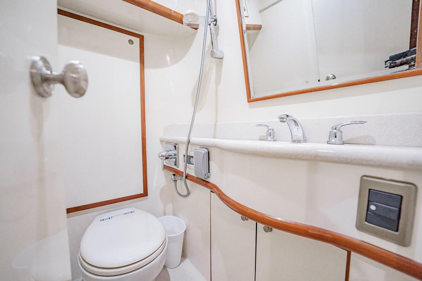 a bathroom with a toilet and a sink aboard THREE OF A KIND Yacht for Sale