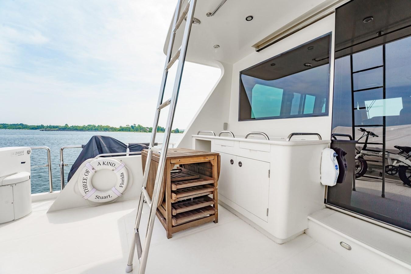 a boat with a chair and a bed in it aboard THREE OF A KIND Yacht for Sale