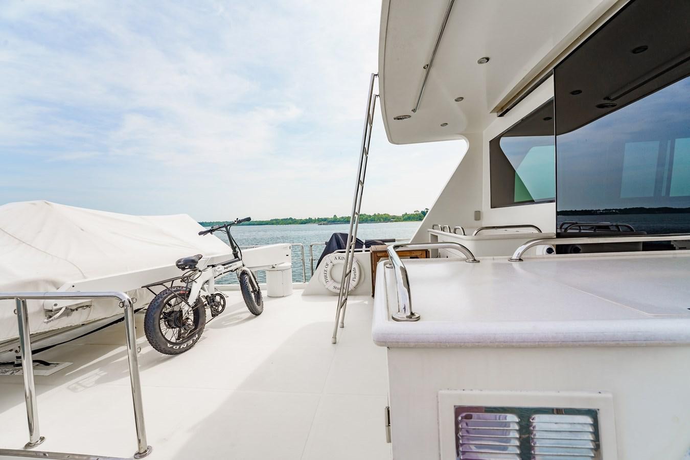 a boat with a motorcycle on it aboard THREE OF A KIND Yacht for Sale