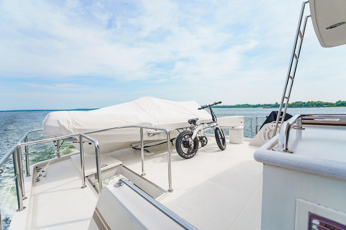 a boat with a bicycle on it aboard THREE OF A KIND Yacht for Sale