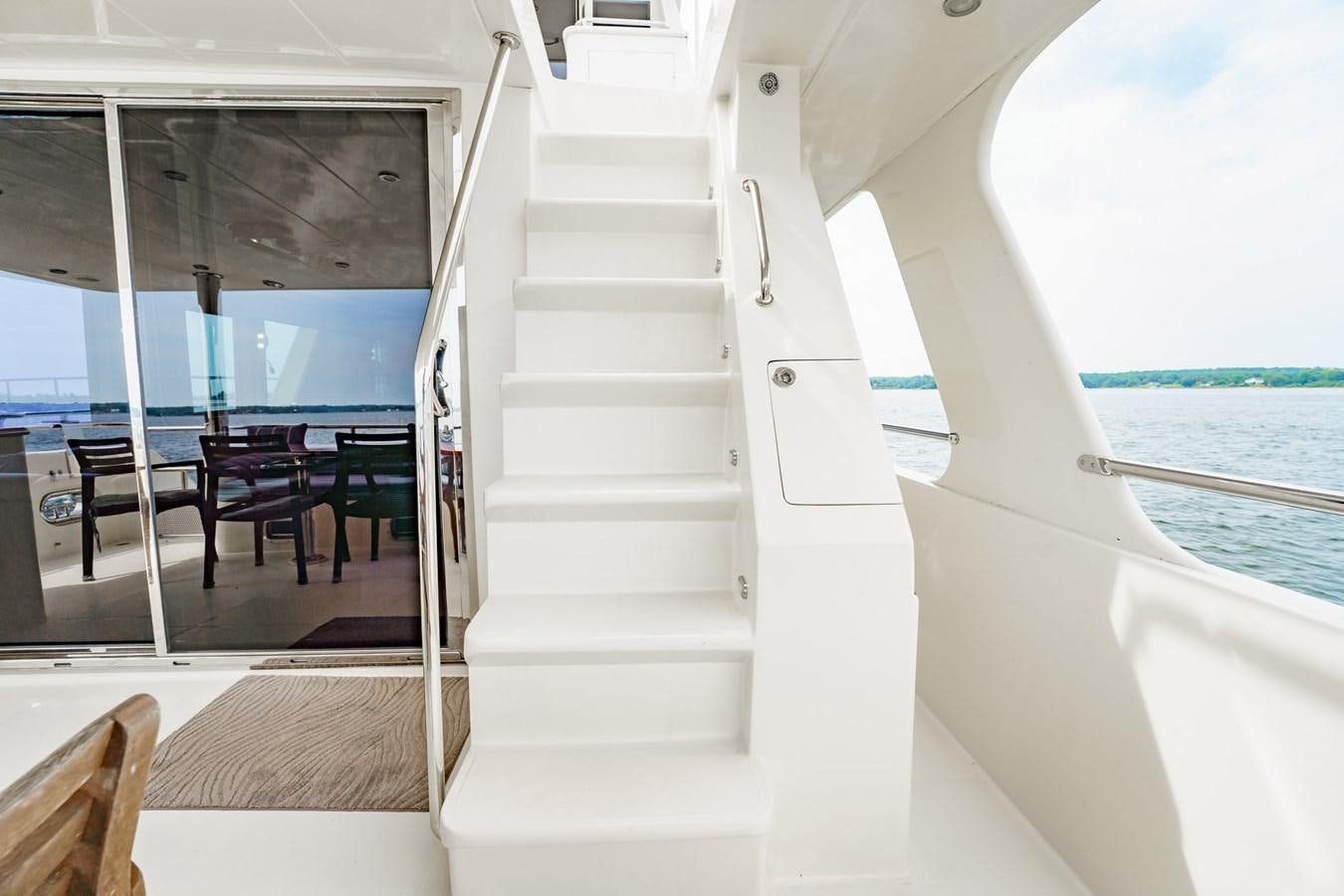 a white staircase with a glass door leading to a beach aboard THREE OF A KIND Yacht for Sale