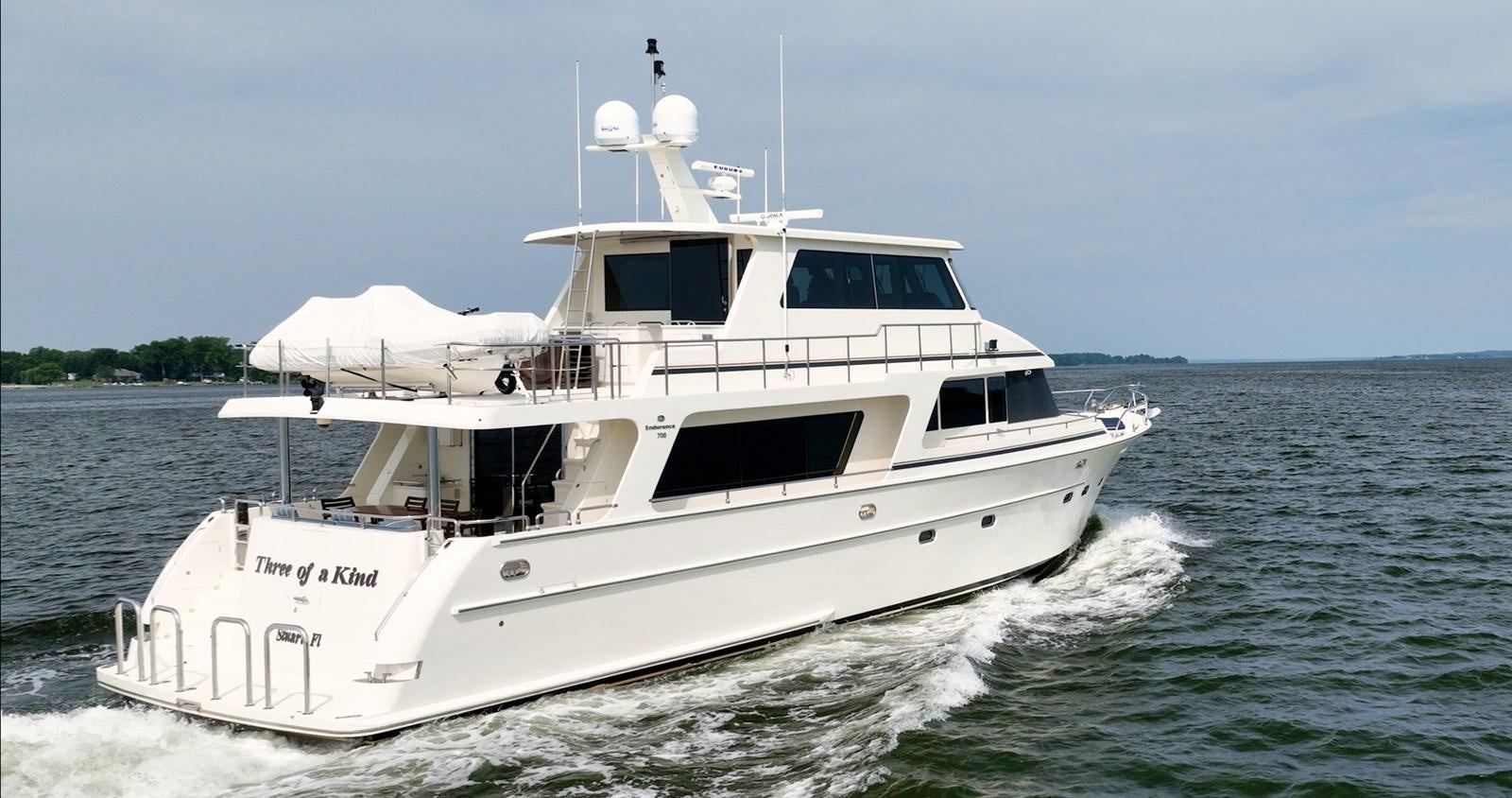 a white boat on the water aboard THREE OF A KIND Yacht for Sale