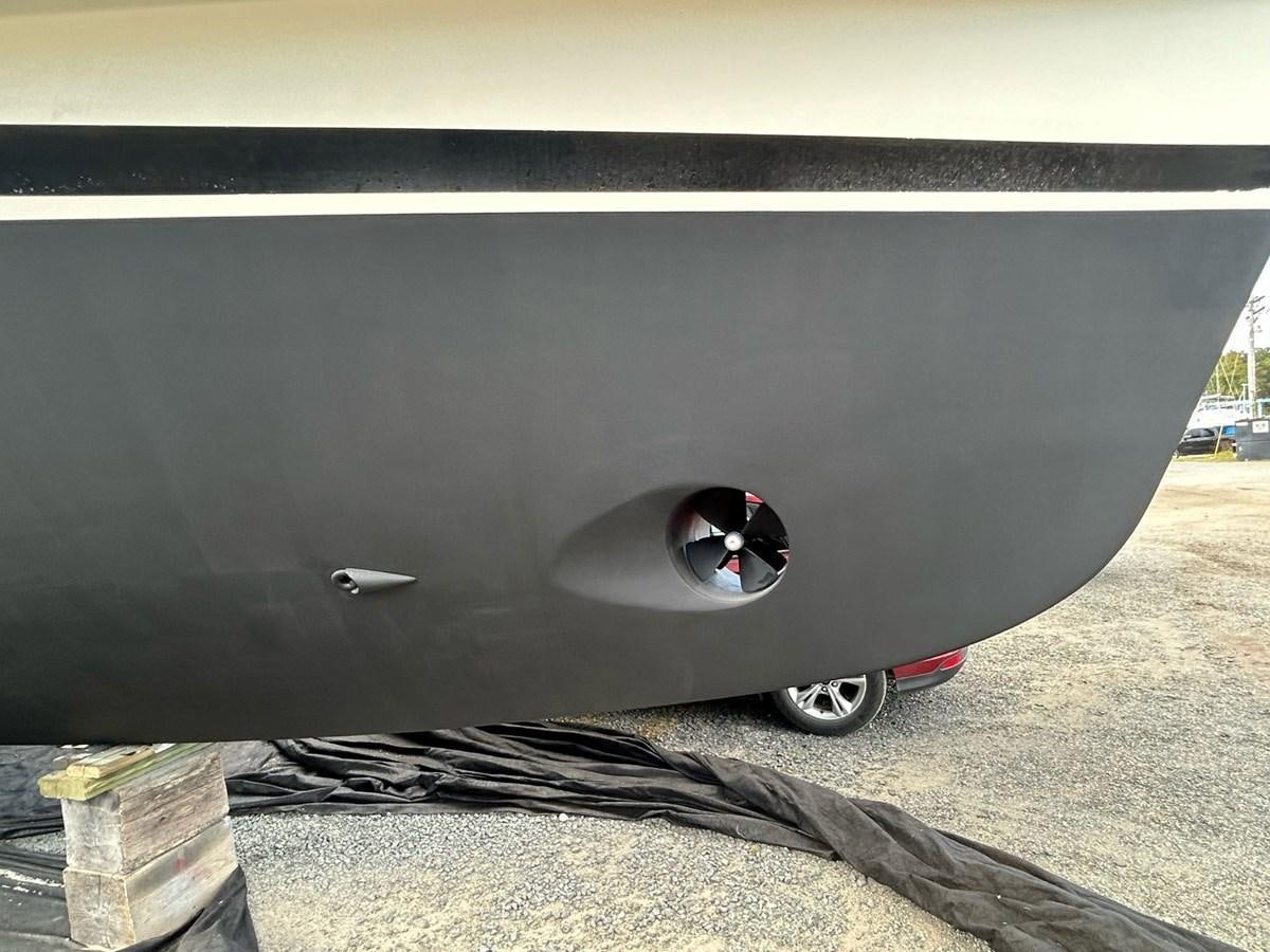a black car with a round hole aboard THREE OF A KIND Yacht for Sale
