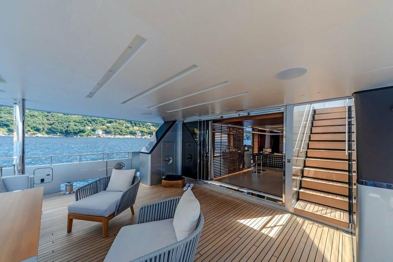 a room with a large deck and a view of the water aboard LADY A Yacht for Sale