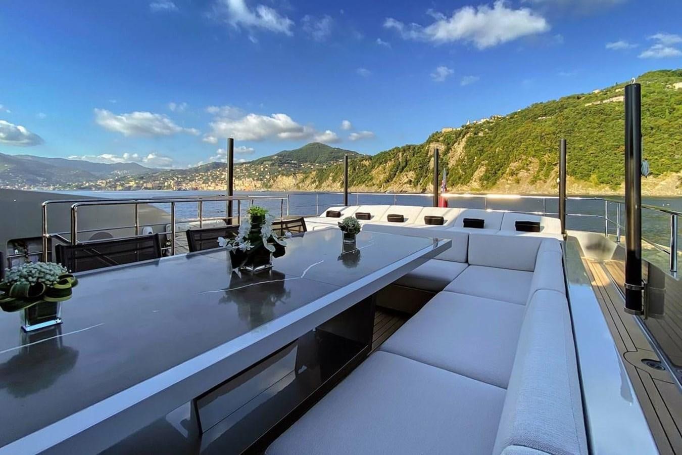 a large pool with a view of a mountain range and blue sky aboard LADY A Yacht for Sale