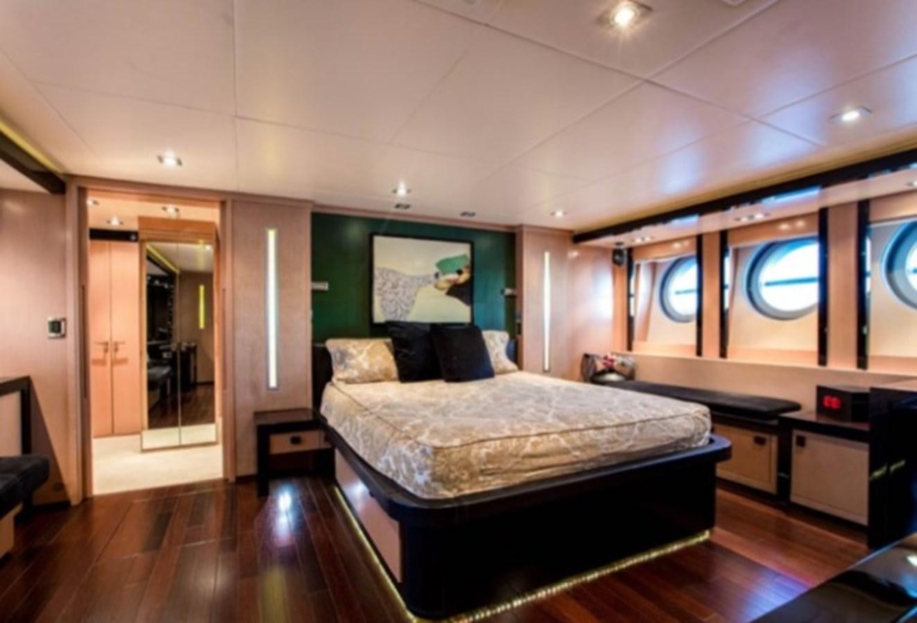 a bedroom with a bed and a desk aboard MY IZUMI Yacht for Sale