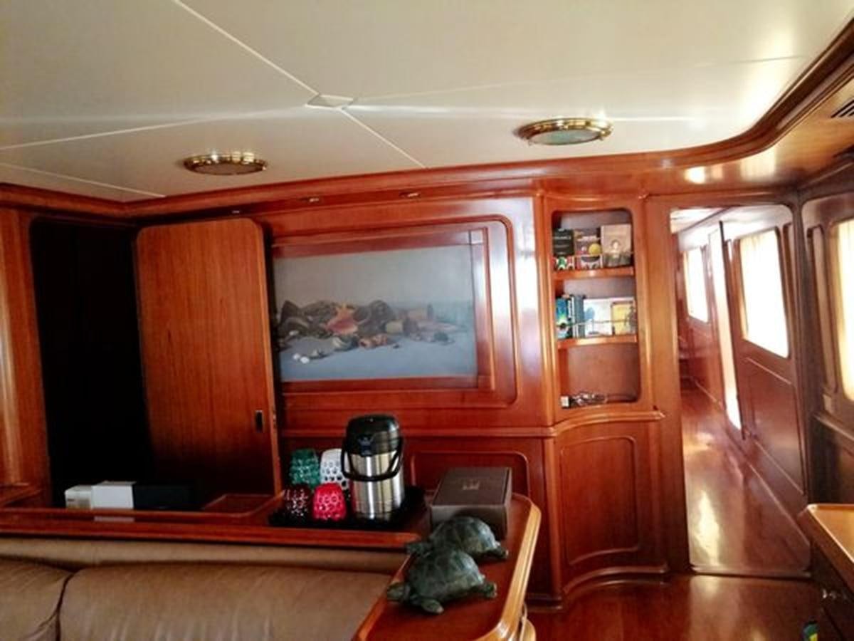 a cat lying on a chair in a room with a wood cabinet aboard PATRA Yacht for Sale