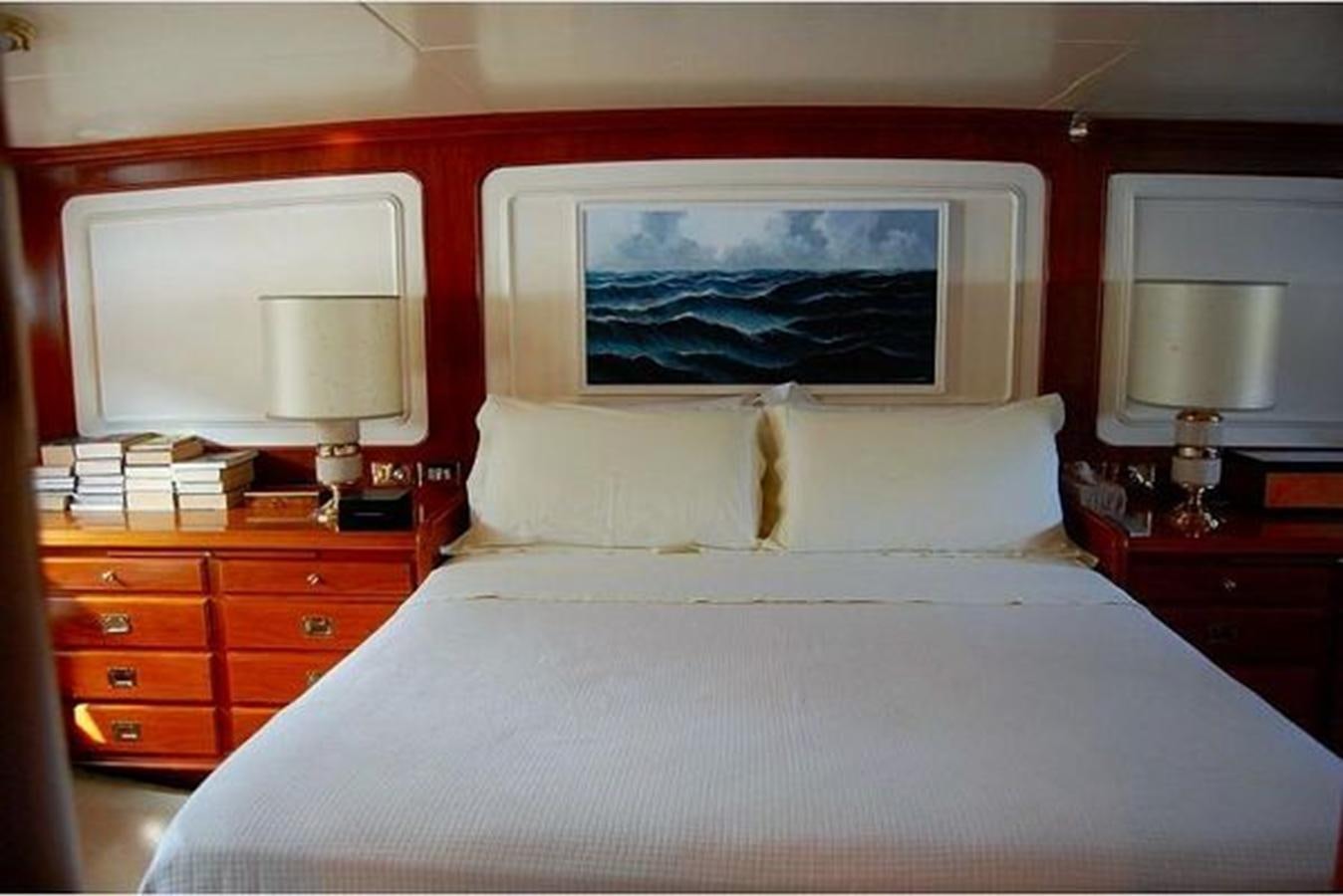a bed with a painting on the wall aboard PATRA Yacht for Sale