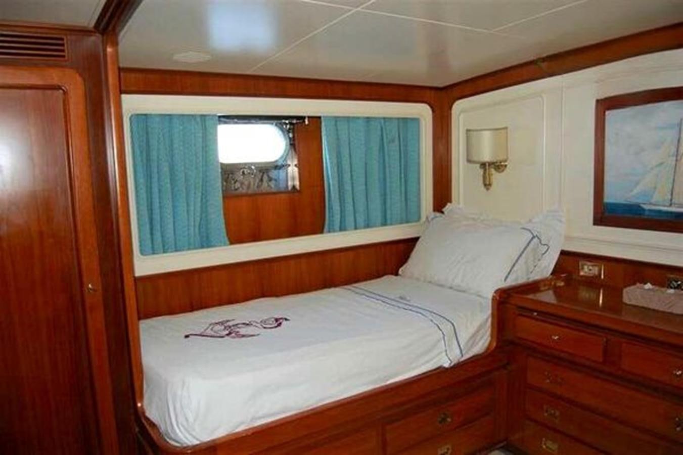 a bed with a white sheet and a window aboard PATRA Yacht for Sale