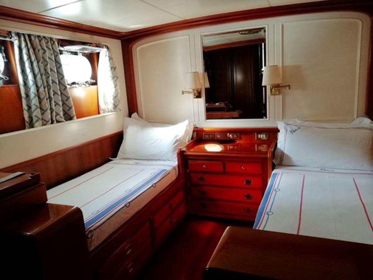 a room with a bed and a dresser aboard PATRA Yacht for Sale