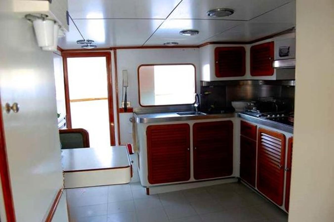 a kitchen with red cabinets aboard PATRA Yacht for Sale