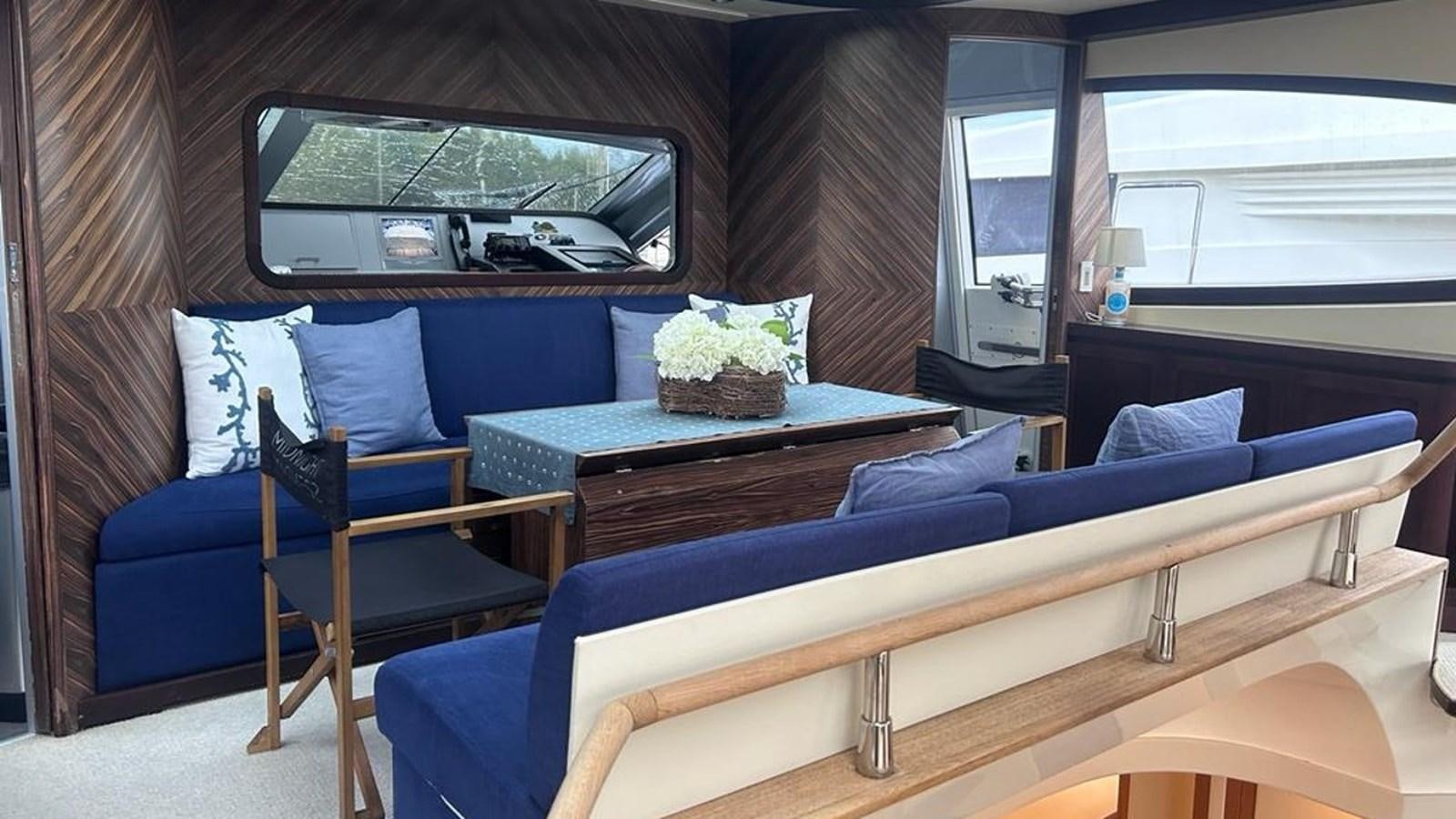 a living room with a blue couch and a television aboard MIDNIGHT MADNESS Yacht for Sale
