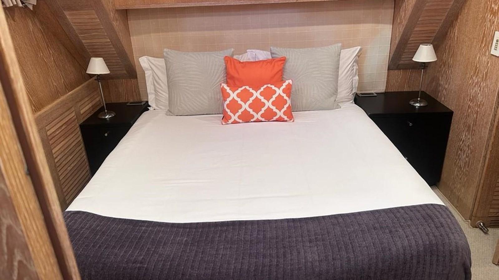 a bed with a white comforter aboard MIDNIGHT MADNESS Yacht for Sale