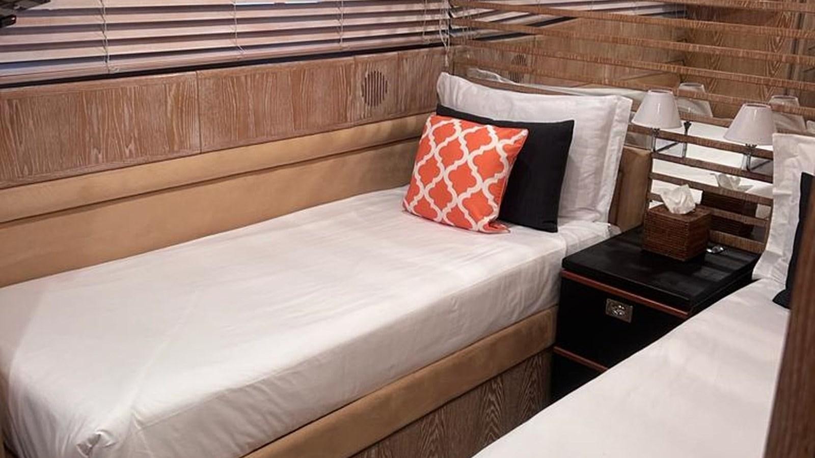 a bed with a white sheet and red pillows aboard MIDNIGHT MADNESS Yacht for Sale