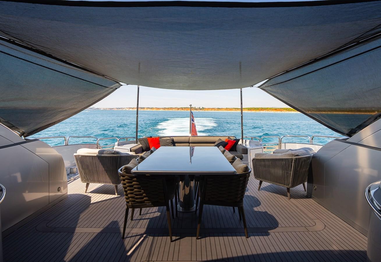 a table and chairs on a deck overlooking a large body of water aboard GEE WHIZZ Yacht for Sale