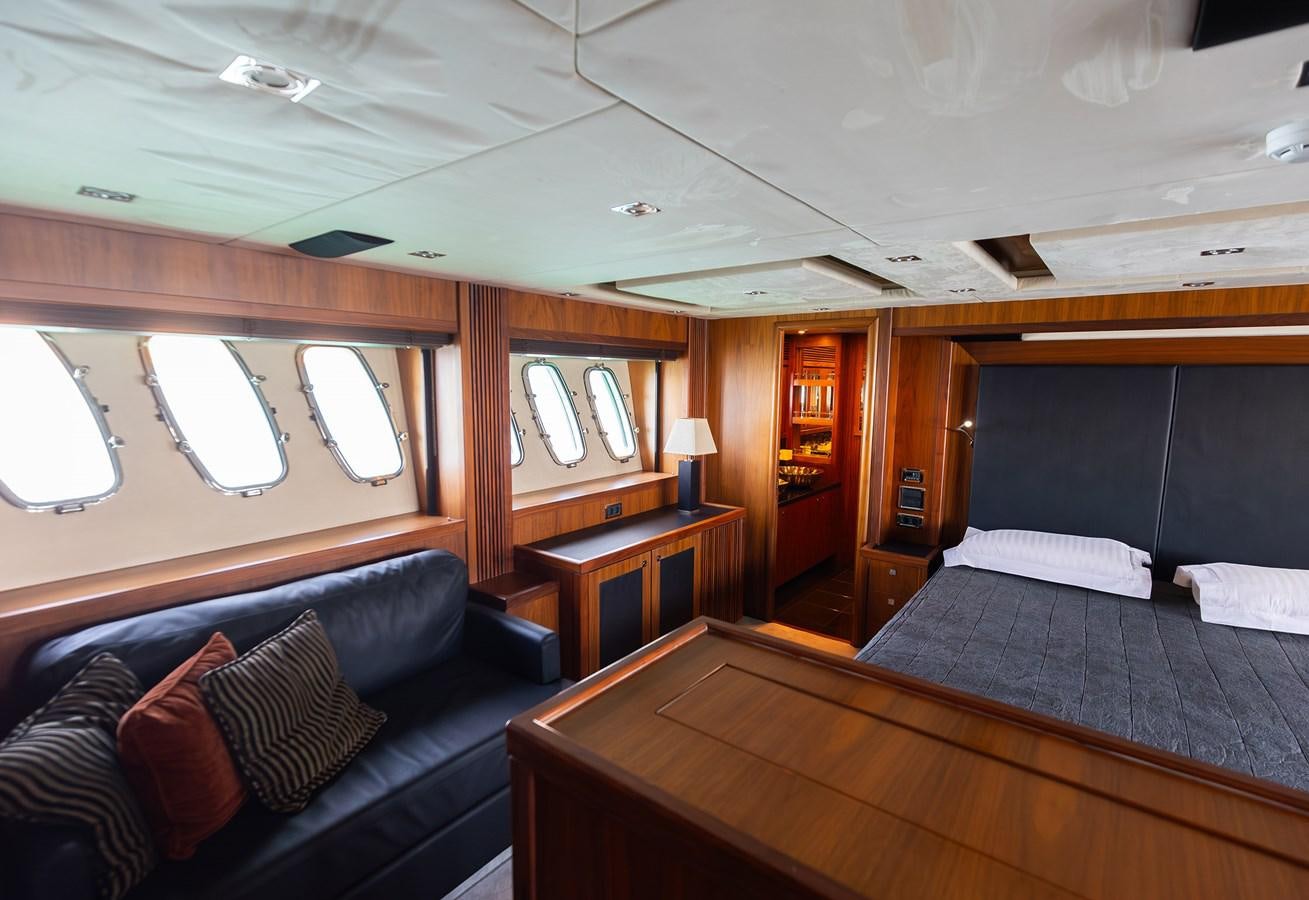 a bedroom with a bed and a couch aboard GEE WHIZZ Yacht for Sale