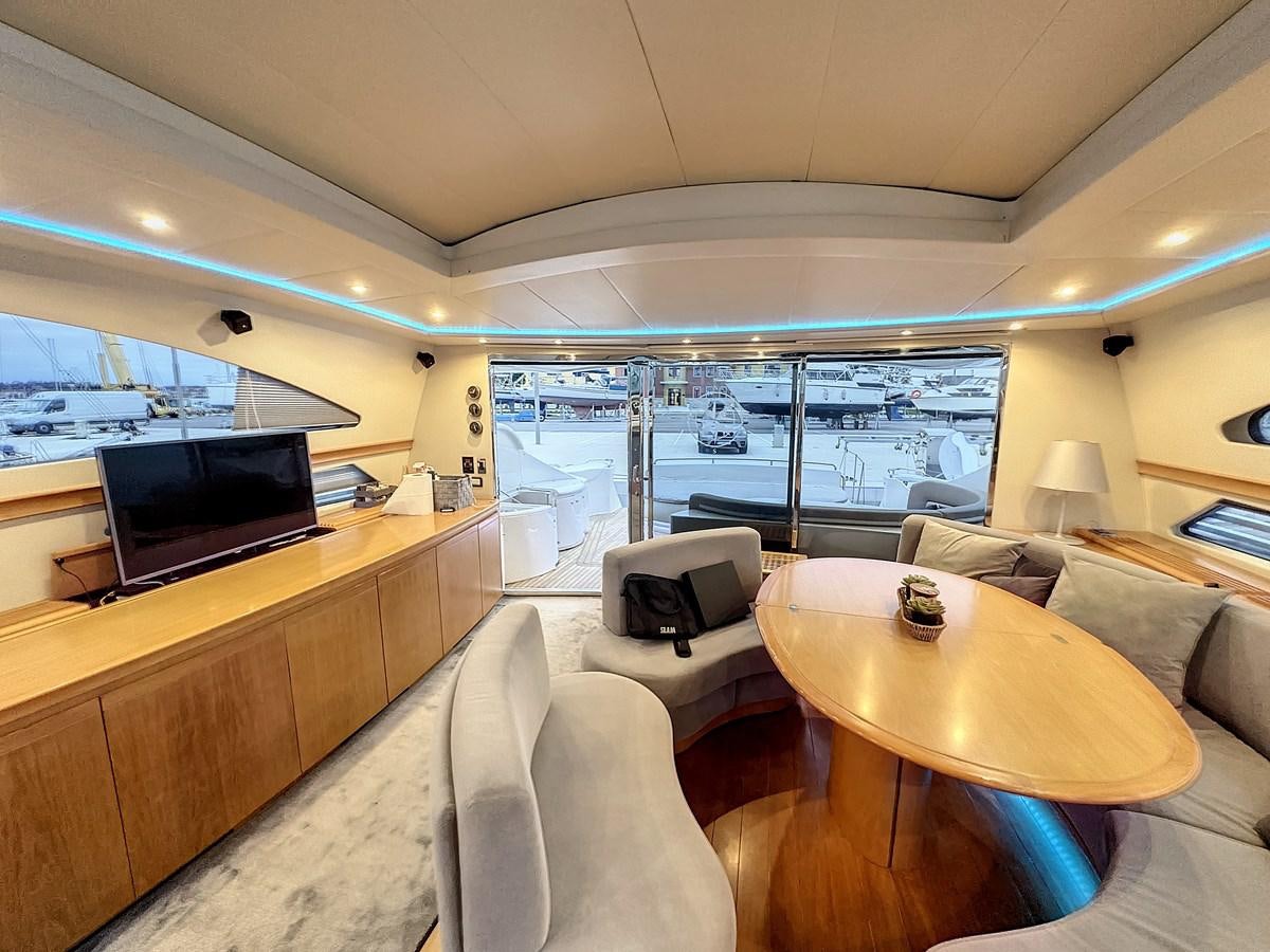 a room with a large window and a table with chairs and a tv aboard NAUTILUS Yacht for Sale