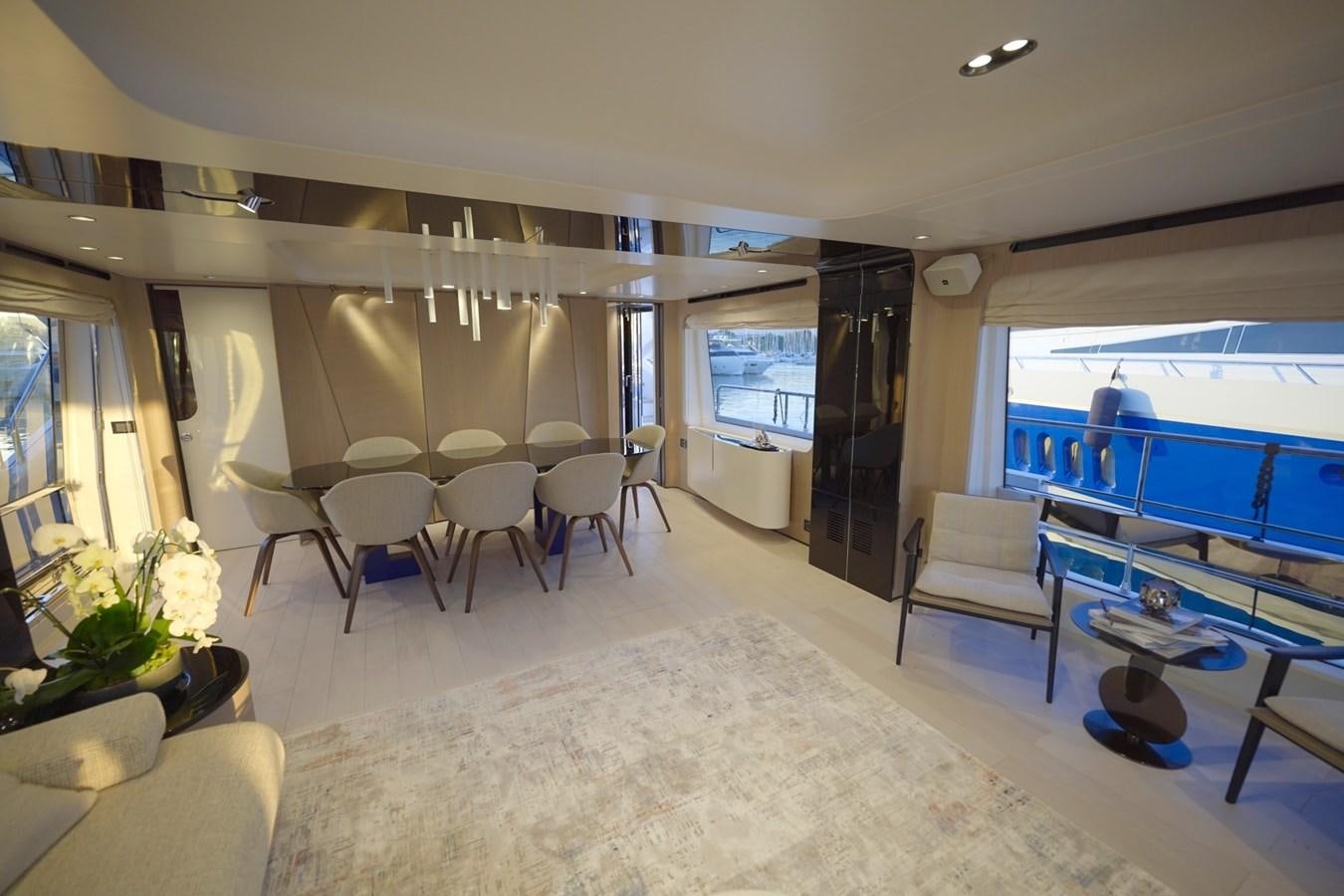 a room with a large window and a table with chairs and a television aboard GRANDE 27M Yacht for Sale