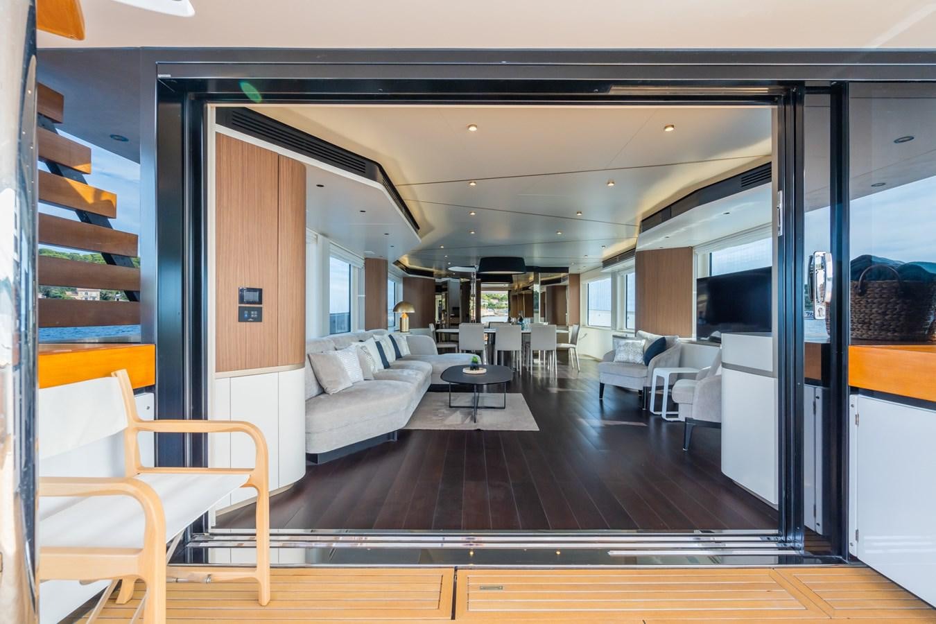 a room with a wood floor and white couches aboard SWG Yacht for Sale