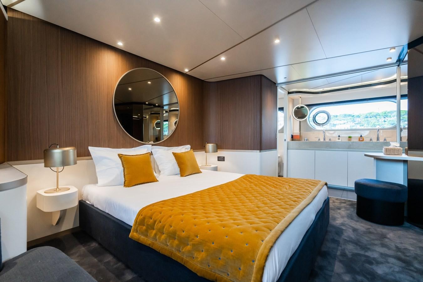 a modern bedroom with a large mirror aboard SWG Yacht for Sale