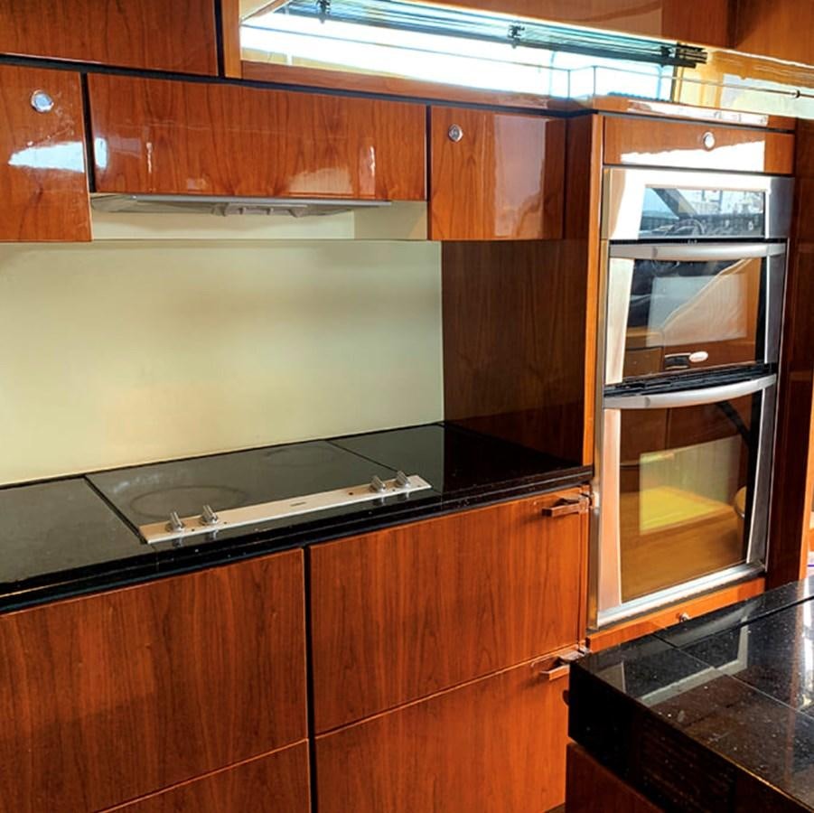 a kitchen with wooden cabinets aboard OCEANA Yacht for Sale