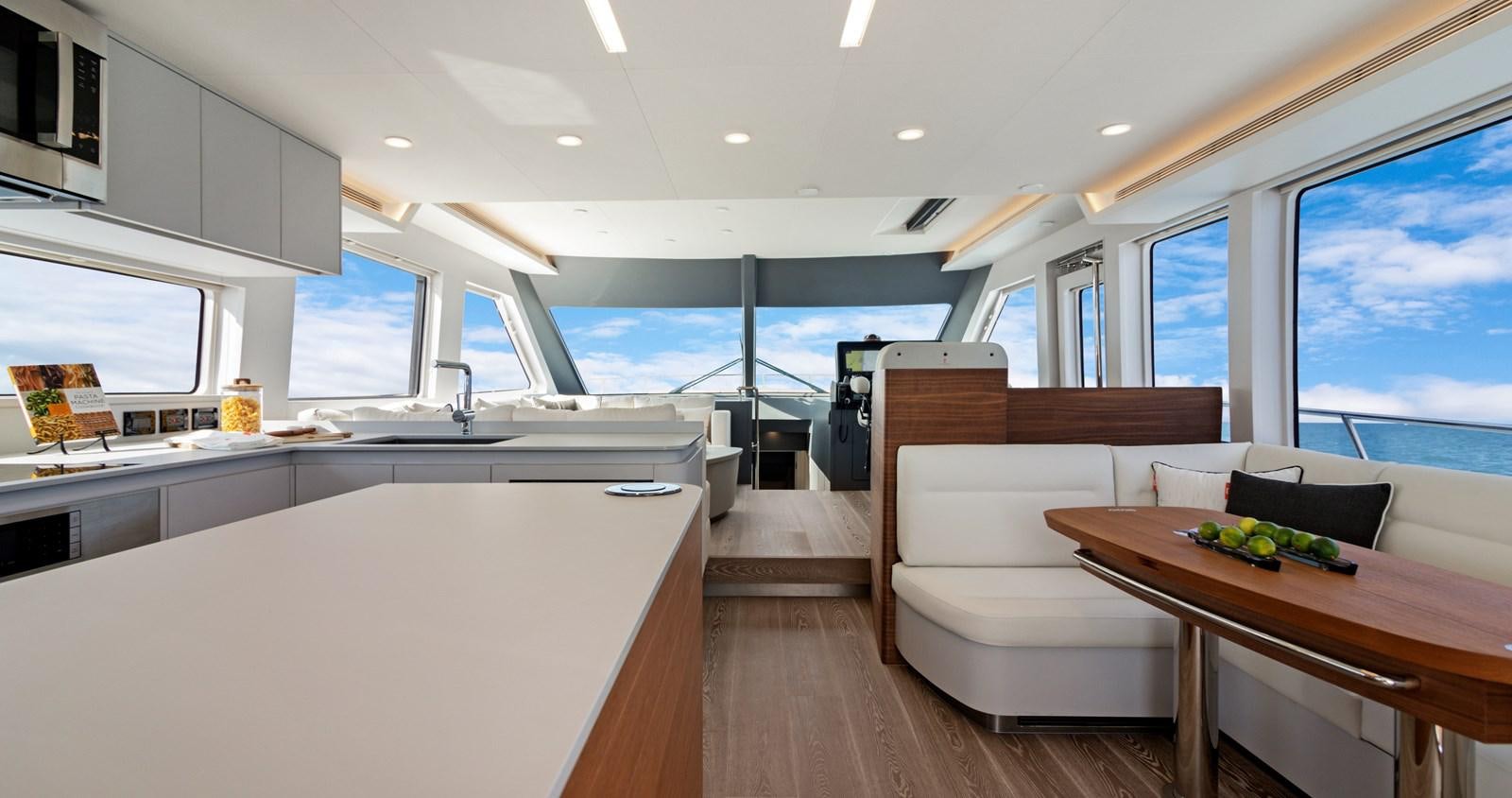 a room with a couch and a table and a large window aboard CLB65 Yacht for Sale