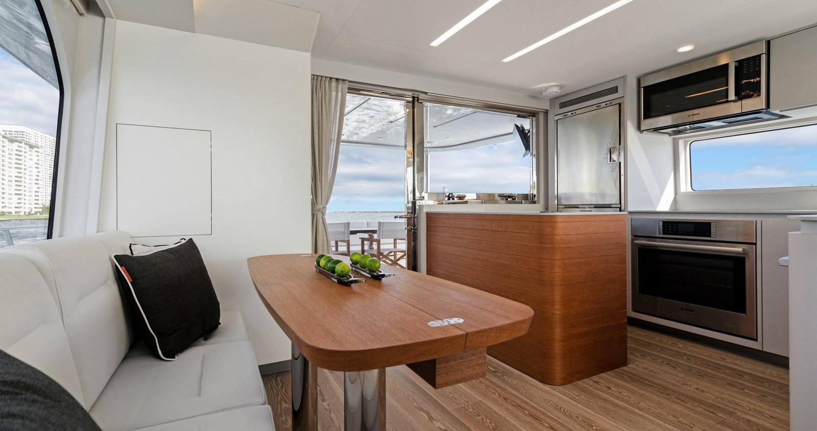 a room with a table and a couch aboard CLB65 Yacht for Sale