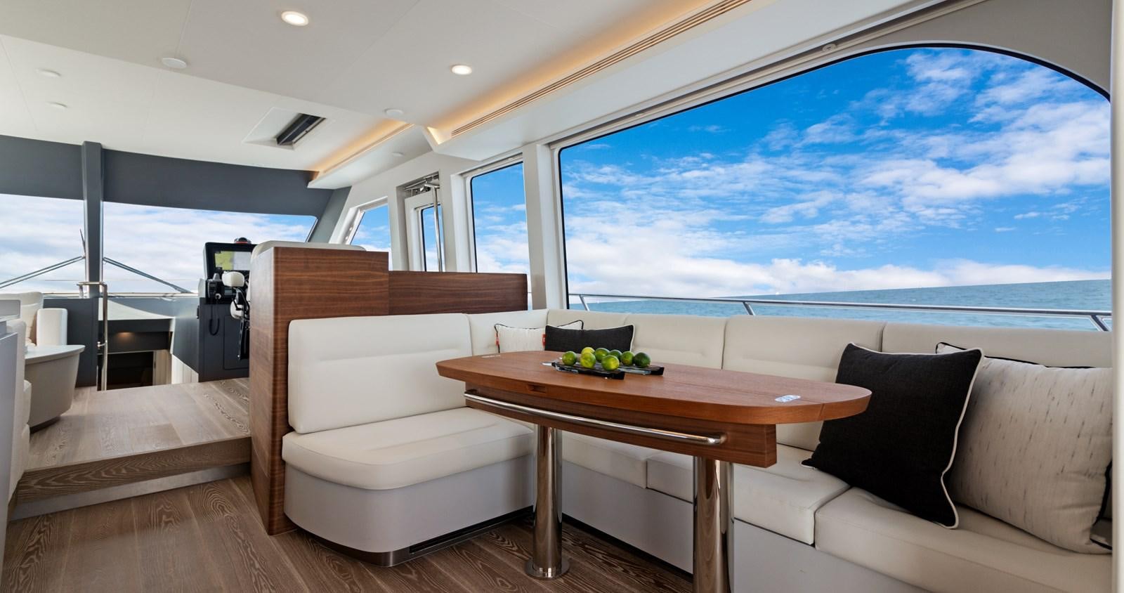 a room with a table and couch aboard CLB65 Yacht for Sale