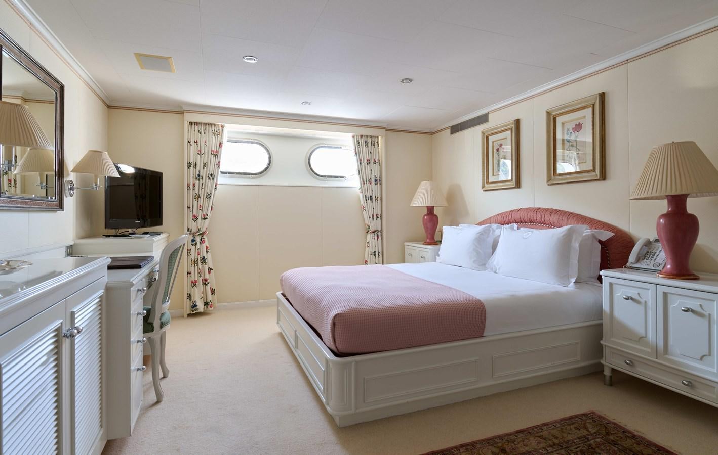 a bedroom with a bed and a desk aboard LADY BEATRICE Yacht for Sale